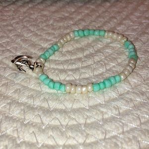One homemade blue and white bracelet with a silver anchor charm